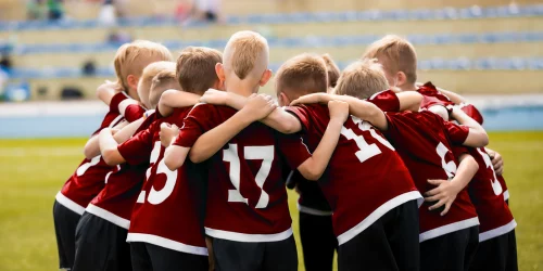 Group of children huddling at a football game