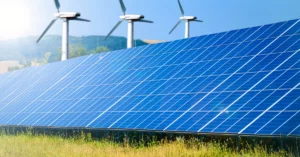 Solar panels with three windmills in the background