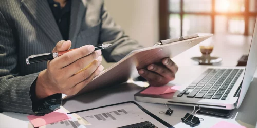How to Perform Effective Internal Audits 1 man at a desk with a clipboard conducting an internal audit